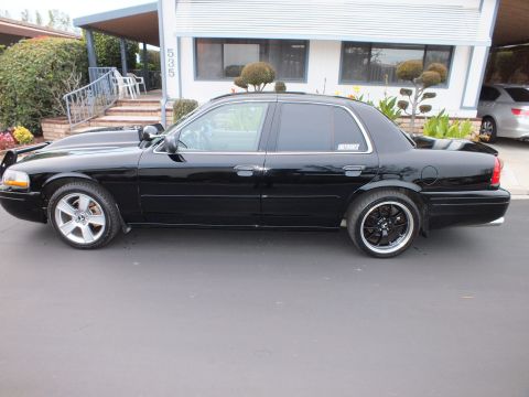 2003 Ford Crown Victoria - Full side profile of a lowered black Crown Victoria sedan on machined-lip black wheels.