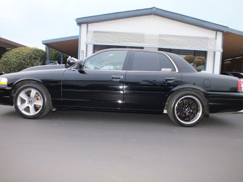 2003 Ford Crown Victoria - Side view of a lowered black Crown Victoria with tinted glass and black spoke wheels.
