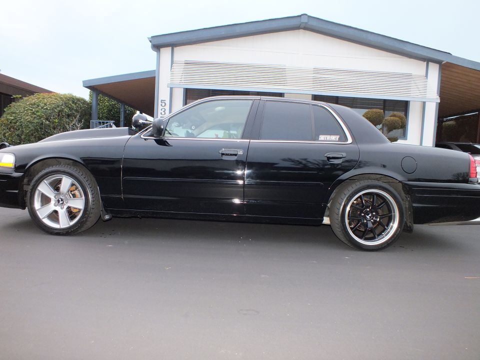 Black Crown Victoria driver-side profile, tinted windows, black machined-lip wheels