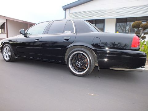 2003 Ford Crown Victoria - Rear-corner view of a lowered black Crown Victoria with spoiler and machined-lip wheels.