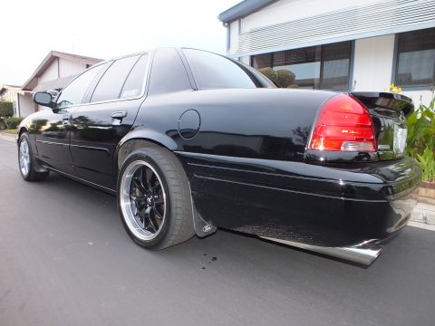 2003 Ford Crown Victoria - Rear three-quarter of a lowered black Crown Victoria with chrome side trim and dual exhaust.