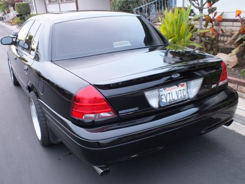 2003 Ford Crown Victoria - Rear view of a black Crown Victoria showing the Ford badge, trunk and chrome-tip exhaust.