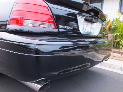2003 Ford Crown Victoria - Close rear-corner view of a black Crown Victoria Police Interceptor with chrome exhaust outlet.