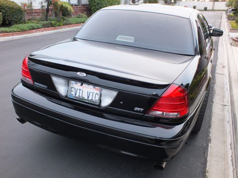 2003 Ford Crown Victoria - Rear-quarter view of a black Crown Victoria with SVT badge and EVIL VIC California plate.