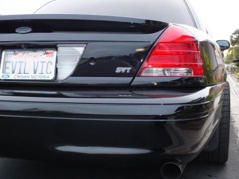 2003 Ford Crown Victoria - Tight rear-corner shot showing the SVT badge, tail light and EVIL VIC plate of a Crown Victoria.