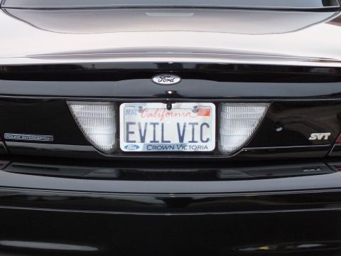 2003 Ford Crown Victoria - Centered rear detail of the EVIL VIC plate flanked by Ford oval, SVT and Police Interceptor badges.
