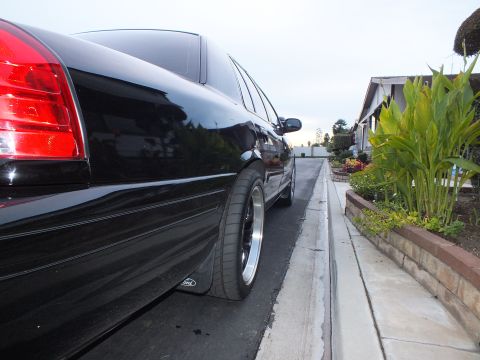 2003 Ford Crown Victoria - Curbside low-angle of a black Crown Victoria sedan riding on staggered polished-lip wheels with low-profile tires.
