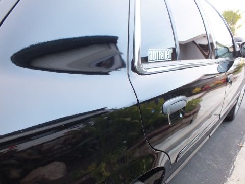 2003 Ford Crown Victoria - Black sedan rear quarter window carrying an AUTR.net decal above the body-color door handle.