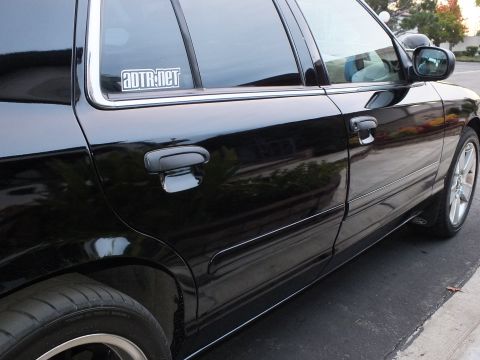2003 Ford Crown Victoria - Side view of a black sedan showing rear door, AUTR.net quarter-window decal and a polished-face wheel.