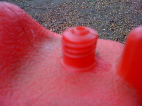 1968 Ford Mustang - This is a close-up view of a red plastic component, showing its textured surface and ribbed details.