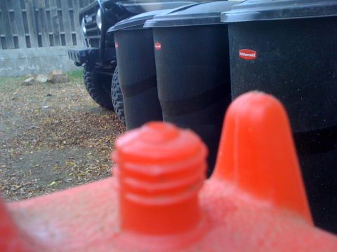 1968 Ford Mustang - An off-road vehicle is parked behind some trash cans, with a red object in the foreground.