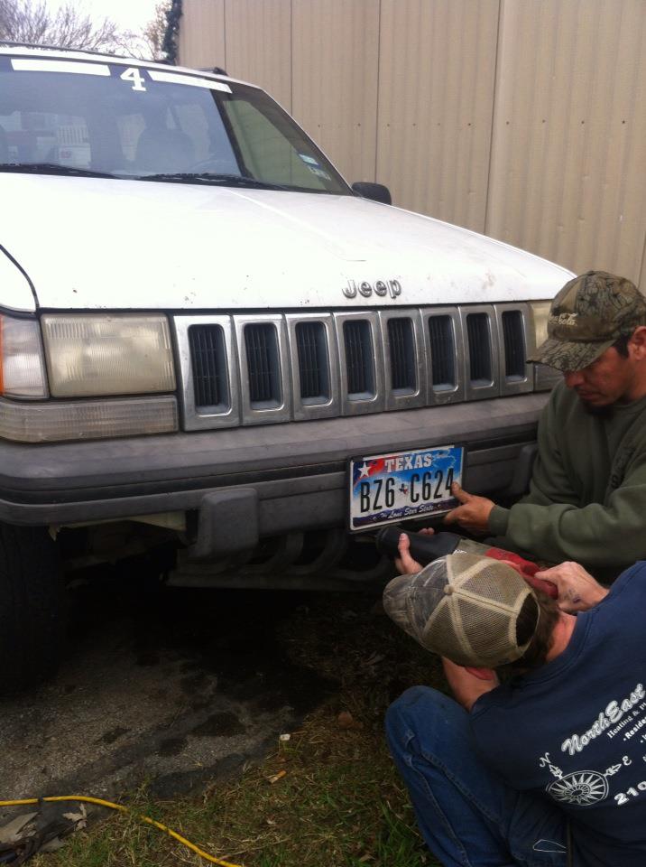 White Jeep Grand Cherokee with a Texas license plate being attached