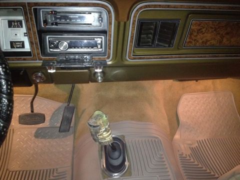 1979 Ford Bronco - The interior of the vehicle features wood grain accents, dual radios, and floor mats.