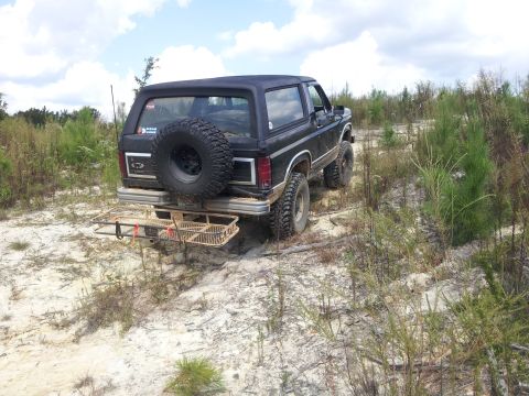 1986 Ford Bronco - This 1986 Ford Bronco is equipped for off-road adventures with its large spare tire, tires, and rear cargo rack.