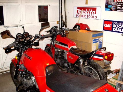2008 Ford Crown Victoria - Two red motorcycles are parked side-by-side in a garage setting.