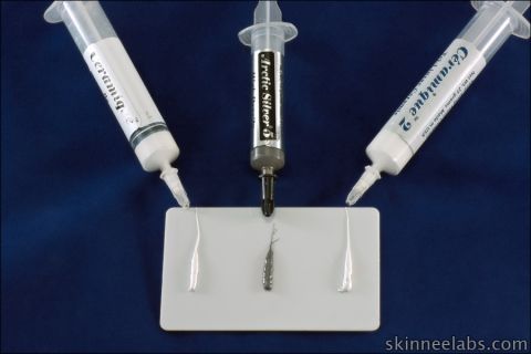 1990 Ford Bronco - Arctic Silver 5 and Ceramique thermal pastes are dispensed from syringes onto a small component.