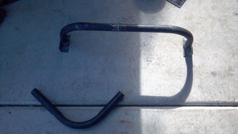 1978 Ford Bronco - Two metal bars, possibly from an anti-roll bar assembly, are shown on a concrete surface.