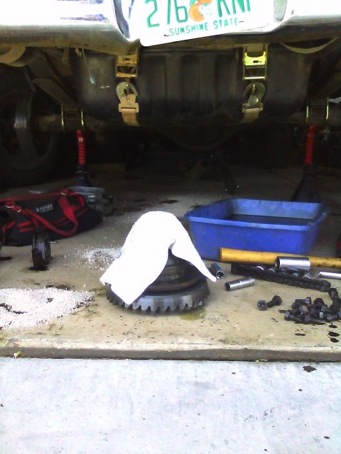 1978 Ford Bronco - Differential gear and assorted tools laid out on the floor, likely for a vehicle repair or upgrade.