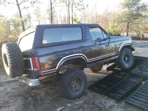 1986 Ford Bronco - This Ford Bronco is being loaded onto a trailer with its rear spare tire visible.