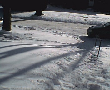 1980 Ford Bronco - A dark-colored SUV is visible in a snowy driveway, partially obscured by snow and shadows.