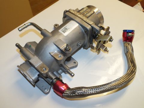 2003 Ford Crown Victoria - Cast-aluminum intake manifold and throttle body bearing a white label, with a braided hose and anodized fittings.
