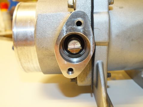 2003 Ford Crown Victoria - Macro view of a two-bolt flange port revealing a slotted shaft inside a machined aluminum casting.