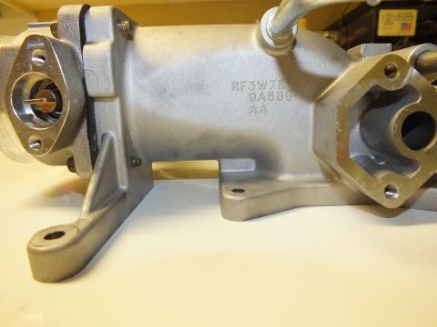 2003 Ford Crown Victoria - Side of an aluminum intake manifold displaying cast markings RF3W7, 9A589 and AA with two machined flanges.