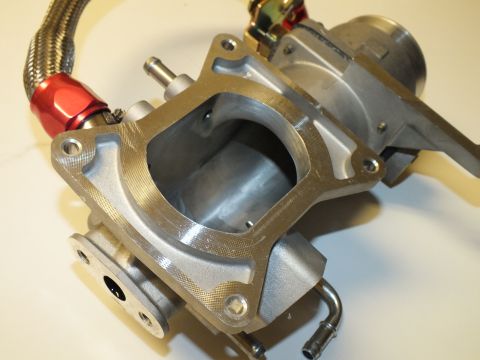 2003 Ford Crown Victoria - Aluminum intake casting showing an open rectangular flange port, lower bosses and a braided hose with red fitting.