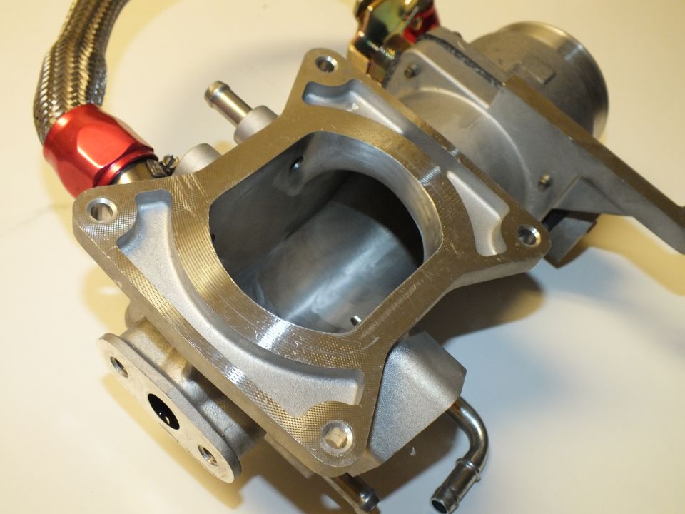 Aluminum intake casting with open rectangular flange port and braided line