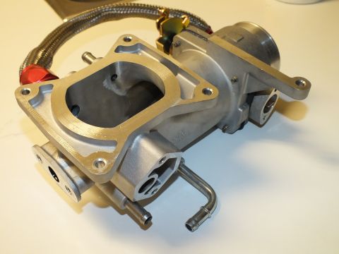 2003 Ford Crown Victoria - Aluminum intake manifold with an open rectangular flange port, cast bosses and a coiled braided line above it.