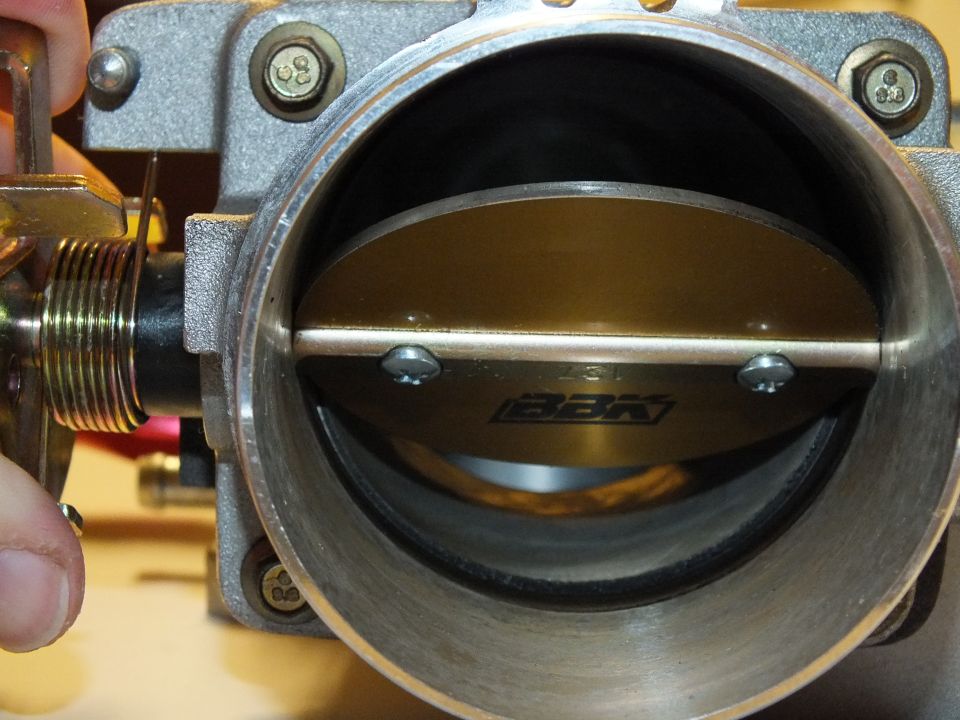 BBK branded throttle plate inside aluminum bore with two visible blade retaining screws