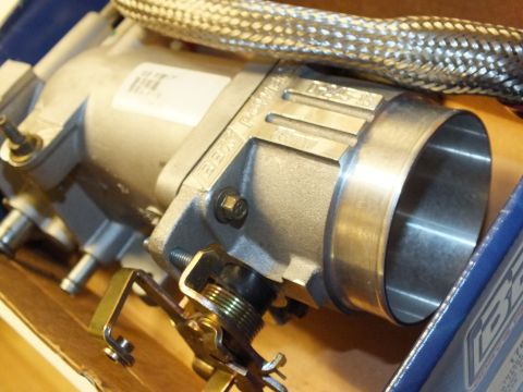 2003 Ford Crown Victoria - Closeup of the BBK throttle body bore and intake casting with a steel-braided hose, packed in a box