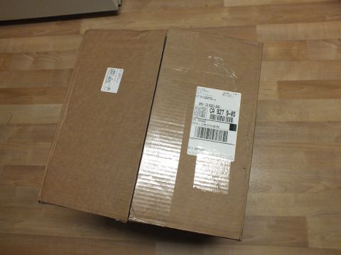 2003 Ford Crown Victoria - Angled view of two sealed kraft boxes with shipping labels and barcodes on a laminate floor