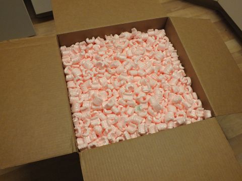 2003 Ford Crown Victoria - Opened shipping carton packed full of pink anti-static foam peanuts sitting on laminate flooring