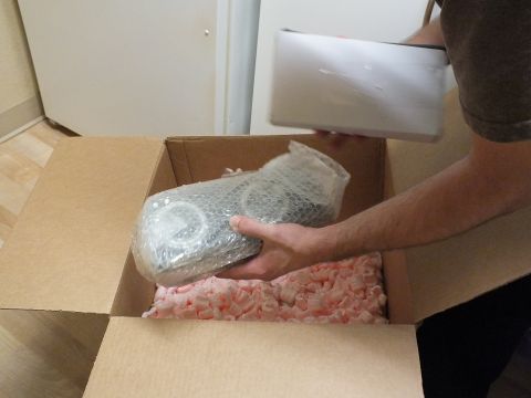 2003 Ford Crown Victoria - person removes a bubble-wrapped component and a white box from a carton of pink foam peanuts