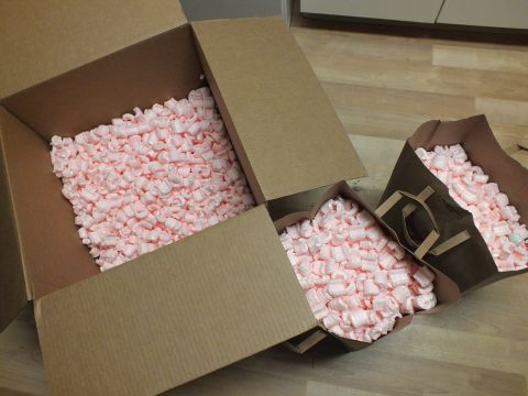 2003 Ford Crown Victoria - Two opened shipping cartons brimming with pink foam packing peanuts arranged on laminate flooring
