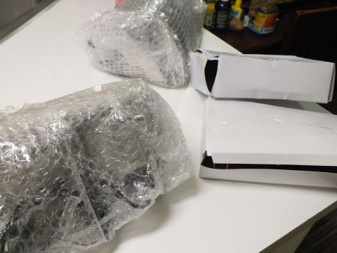 2003 Ford Crown Victoria - Two parcels wrapped in bubble wrap sit beside white cardboard boxes on a tabletop.
