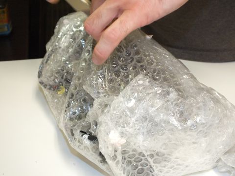 2003 Ford Crown Victoria - Bubble wrap pulled back to reveal a wired part with yellow connectors underneath.