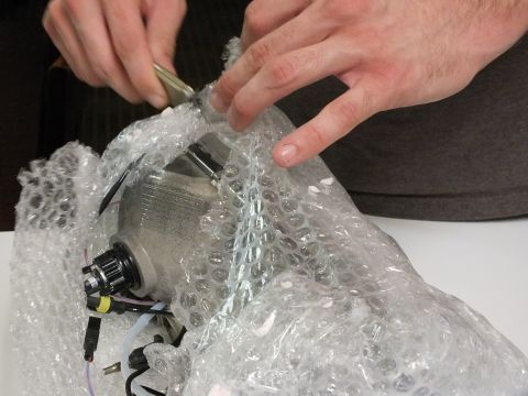 2003 Ford Crown Victoria - Scissors cut packaging away from a headlight assembly fitted with HID connectors.