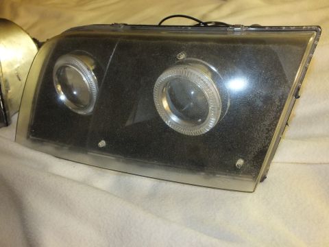 2003 Ford Crown Victoria - Close view of a smoked black projector headlight with two halo rings on a blanket.