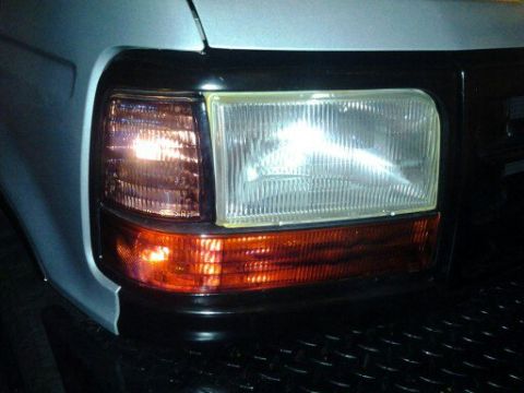 1996 Ford Bronco - Close-up of the headlight and amber turn signal assembly on a 1996 Ford Bronco.