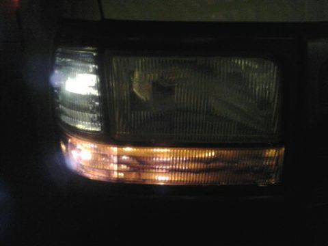 1996 Ford Bronco - Close-up of the front headlight and turn signal assembly on a 1992 Ford Bronco.