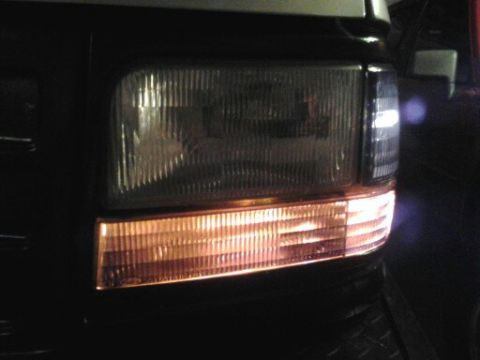 1996 Ford Bronco - Close-up of the front headlight and amber turn signal assembly on a 1996 Ford Bronco.