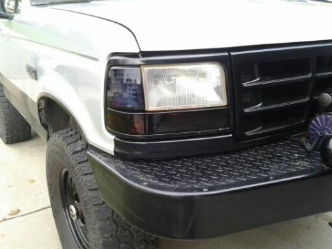 1996 Ford Bronco - This 1996 Ford Bronco features a black grille and diamond plate bumper, seen from a three-quarter front perspective.
