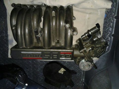 1996 Ford Bronco - A Ford 5.8L intake manifold with throttle body is shown, likely for an engine rebuild or upgrade.