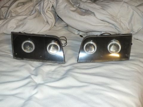 2003 Ford Crown Victoria - Aftermarket projector headlamps showing illuminated halo rings and lens part markings.