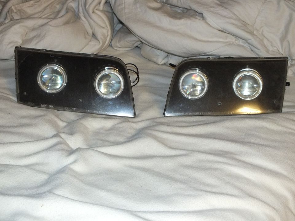 Pair of dual-projector headlights with chrome halo rings and etched lens markings