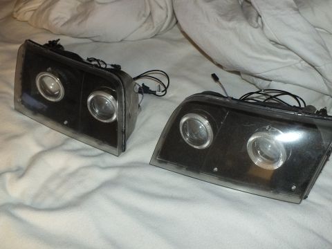 2003 Ford Crown Victoria - Aftermarket headlamp pair showing twin projectors, halo rings and connector pigtails.