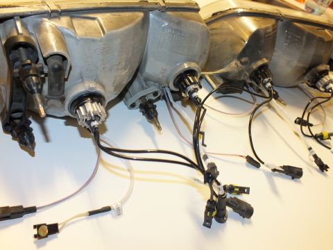 2003 Ford Crown Victoria - Backsides of headlamp assemblies showing Ford logos, bulb retainers and HID harness leads.