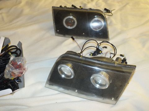 2003 Ford Crown Victoria - Custom headlamp pair beside loose HID conversion components and hardware.